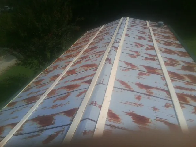 Rusted metal roof panels with new wood purlins before replacement — Storm Damage Roof Repair in Welda by Roofing Brothers