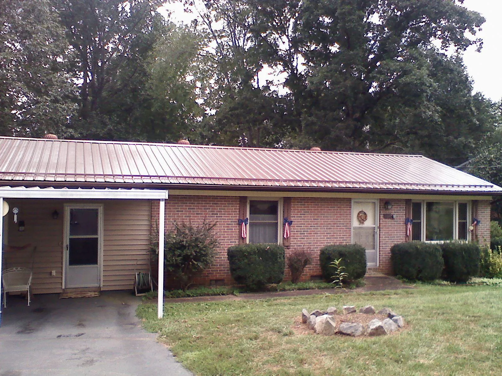 Bronze metal roof and carport on a brick ranch home — Roof Repair work by our crew in Welda